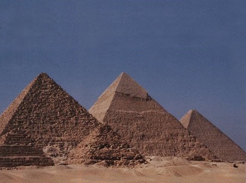 The three main pyramids at Giza, seen here from the southwest, are echoed by three small satellite pyramids just south of the nearest one, constructed by the pharaoh Menkaure. The pyramid of Khafre is beyond it and to the right. It appears to be the tallest, but the Great Pyramid, in the distance, surmounts all of Egypt's 70-odd pyramids. Courtesy E.C.Krupp.